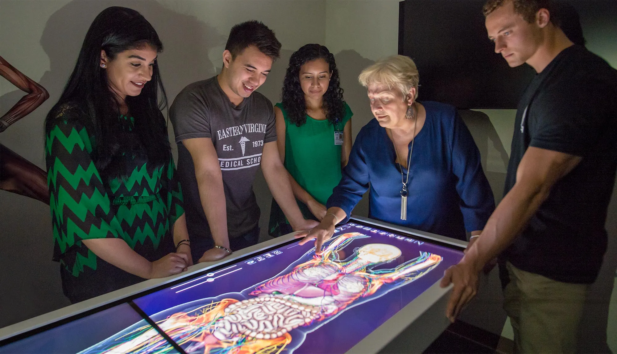 Contemporary Human Anatomy students inspect an interactive anatomage table.