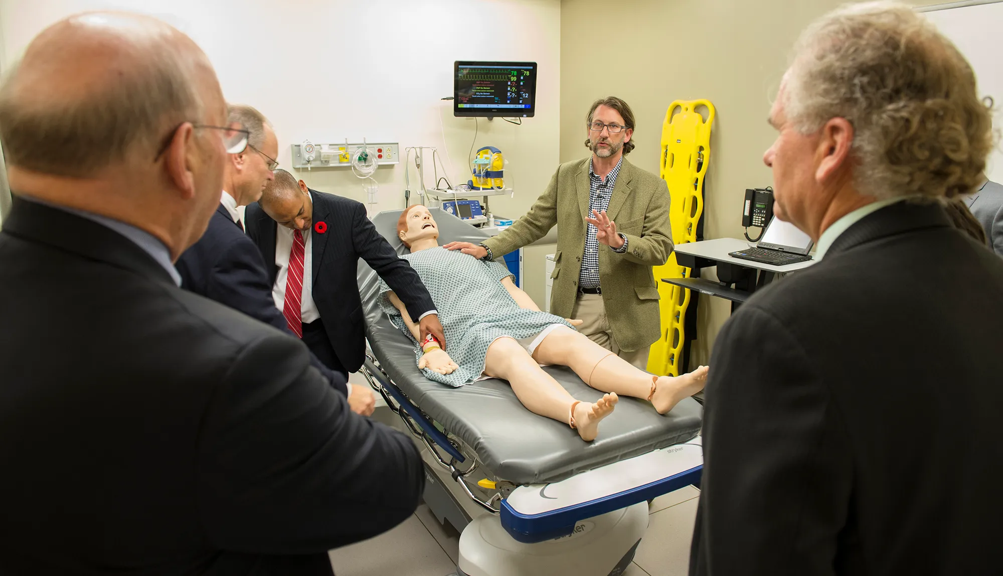 Faculty and staff surround a training manikin in the Sentara Center for Simulation and Immersive Learning at EVMS.